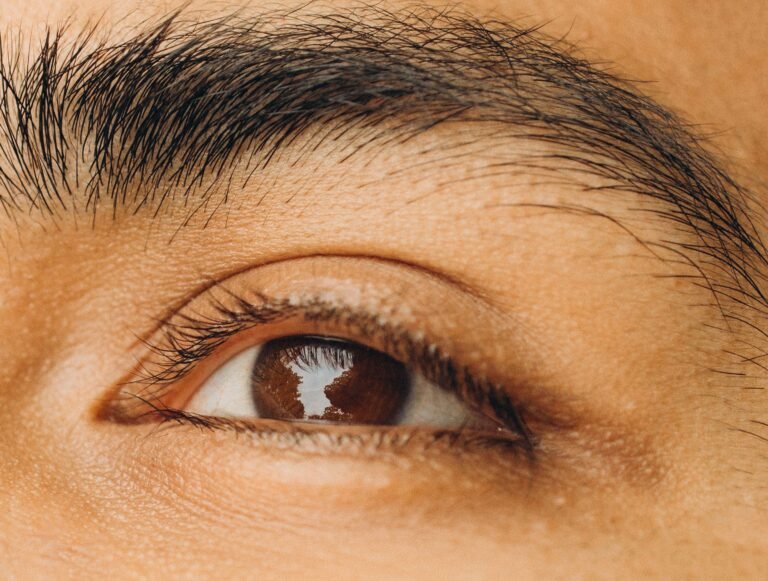 Macro shot of a person's brown eye highlighting texture and reflection in high detail.